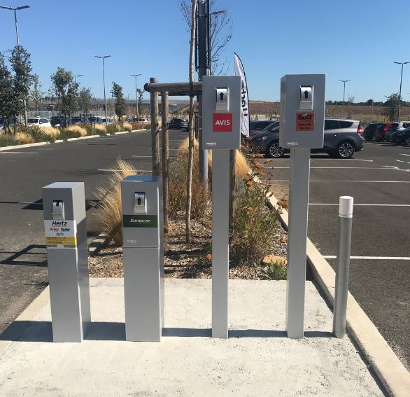 boite à clé sur pied pour agence de location de voiture dans un parking d'aéroport